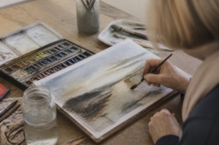 Aquarellkasten, Pinsel und angefangenes Bild