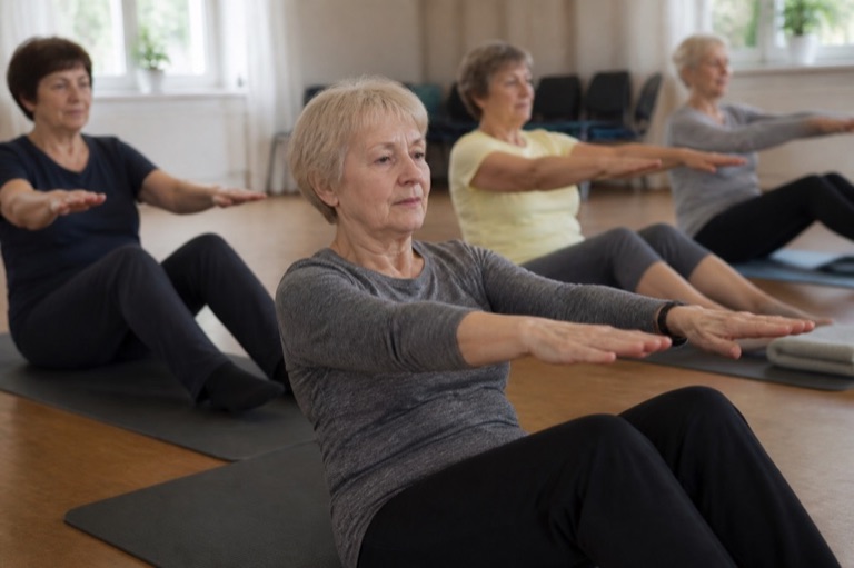 Kursgruppe bei einer Übung auf Gymnastikmatten