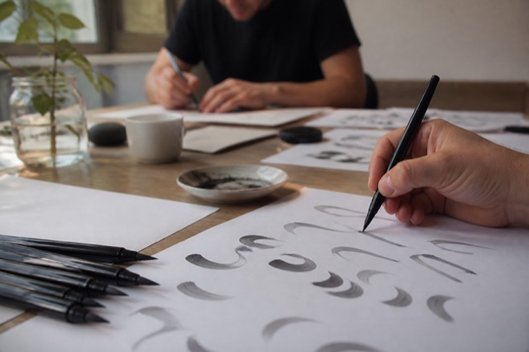 Brushpen und Übungsblatt mit Schwüngen