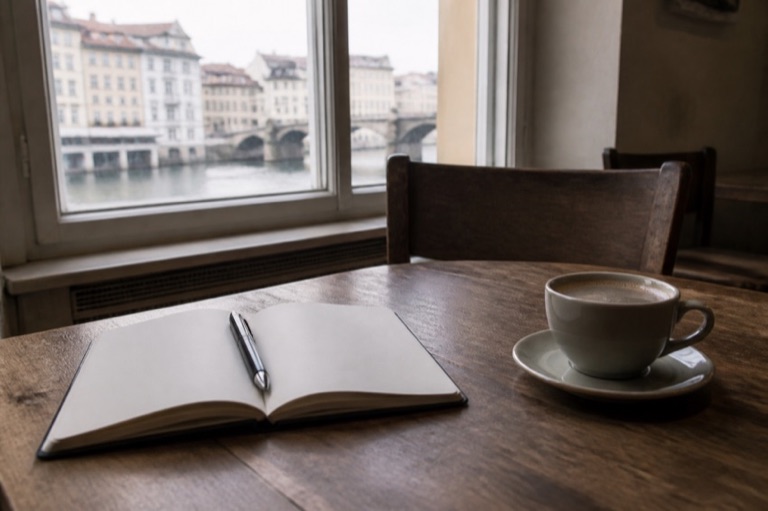 Aufgeschlagenes Notizbuch mit Stift am Fenster