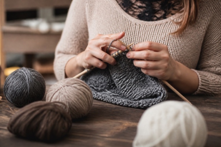 Hände beim Stricken mit Wolle